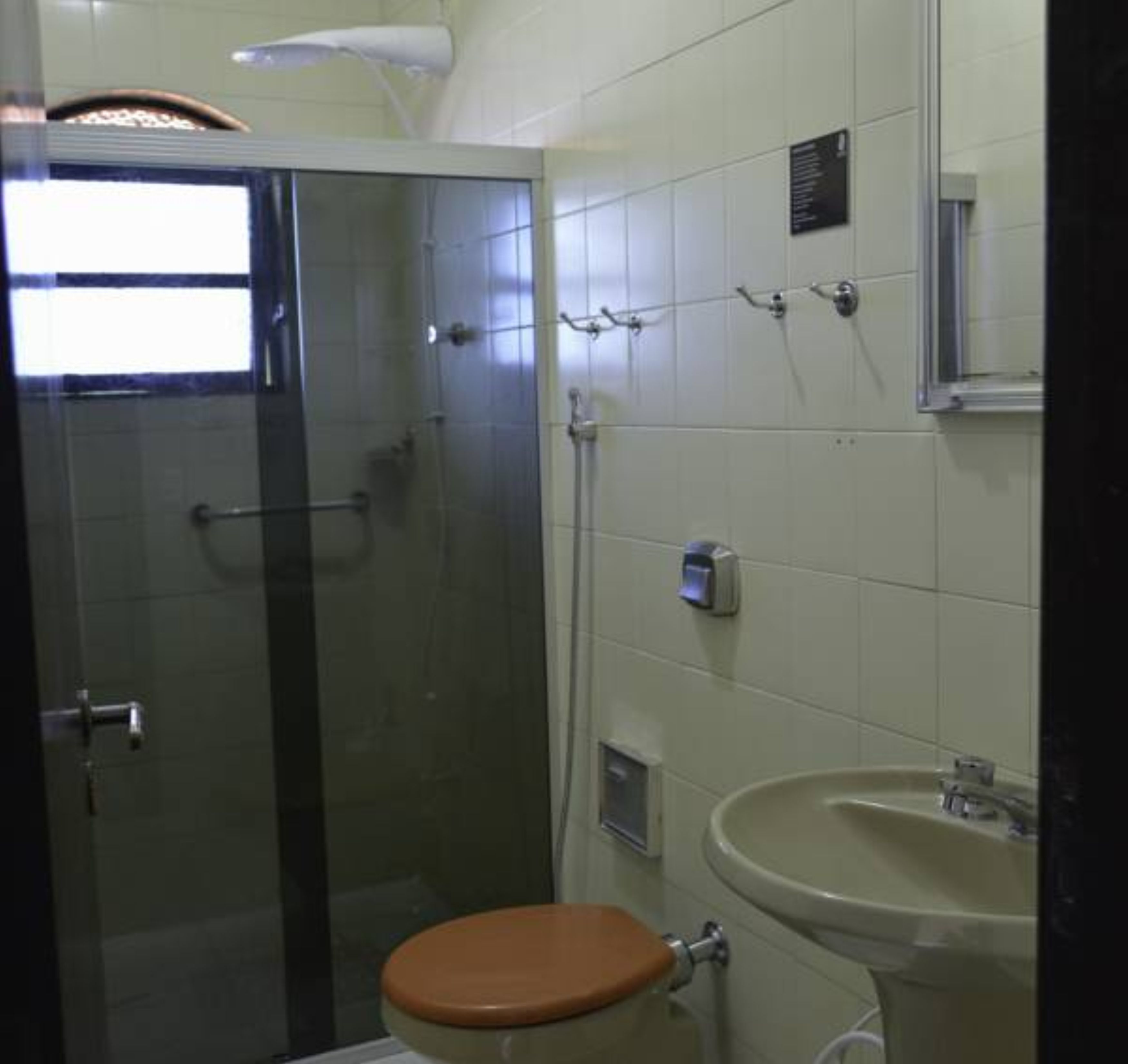 A bathroom with a glass-enclosed shower, a toilet, and a sink.