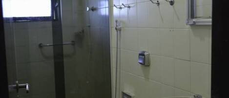 A bathroom with a glass-enclosed shower, a toilet, and a sink.