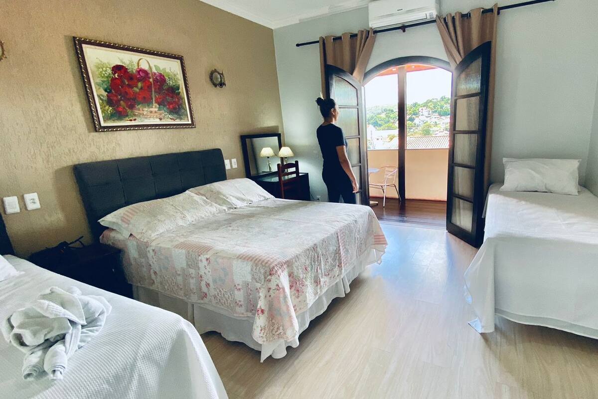Habitación de hotel con dos camas, un balcón y un cuadro en la pared.