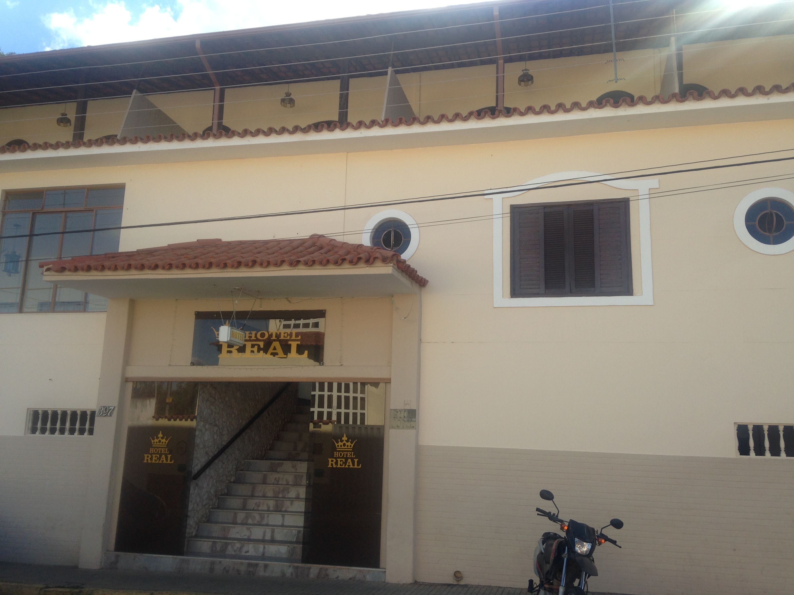 A building with a sign reading "HOTEL REAL" and a staircase leading to the entrance.