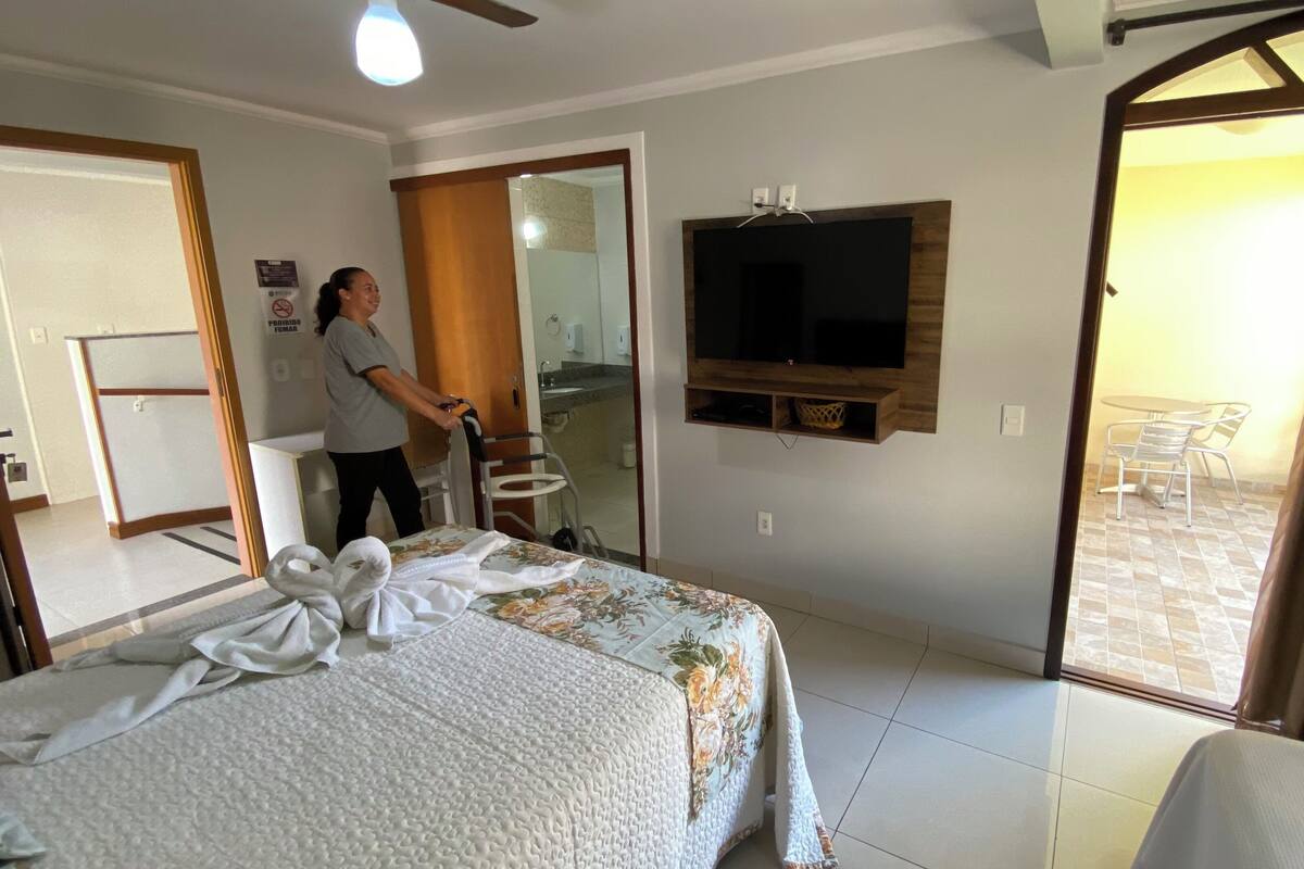 Habitación de hotel con cama, televisión, baño y vistas al exterior.