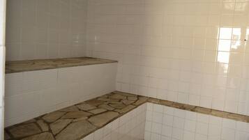 Bathroom features a tiled wall and stone countertop.