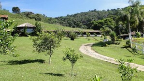 Un paisaje verde exuberante con un sendero curvo que conduce a un edificio con tejado de azulejos.