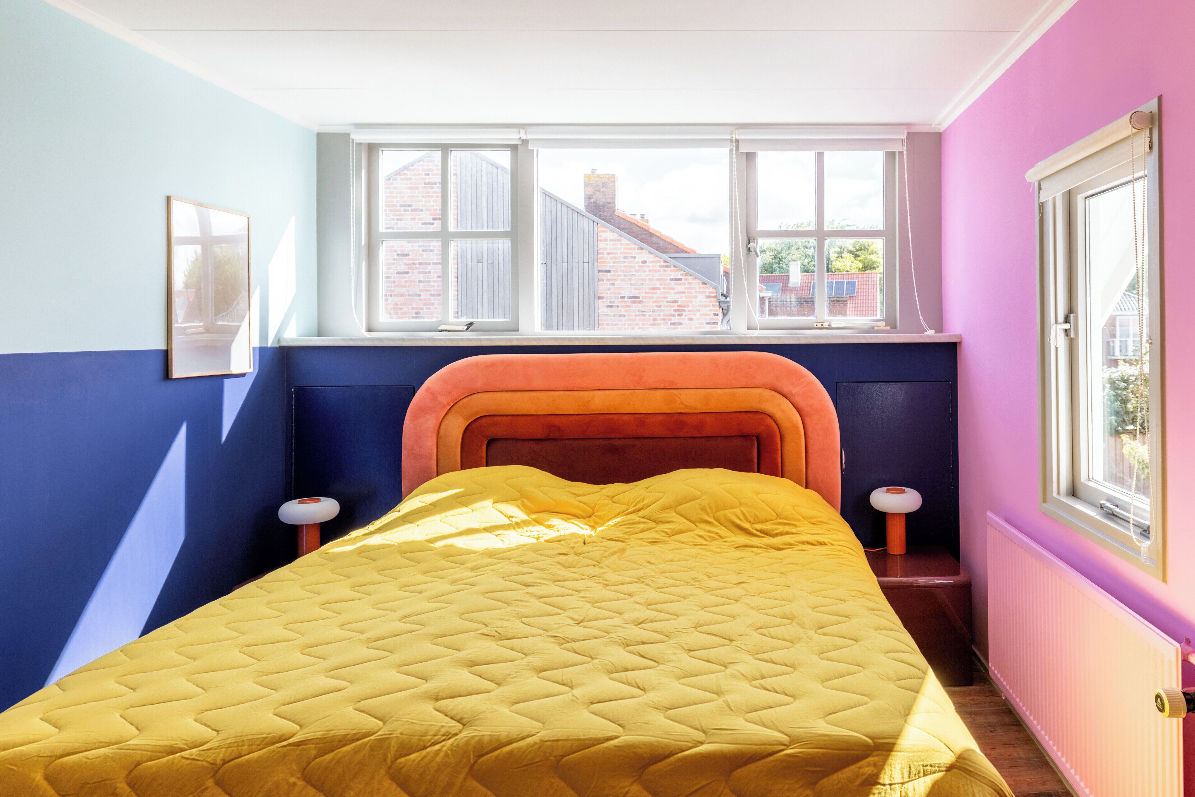 Una habitación con cama, ventana y radiador.
