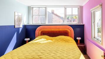 A room with a bed, a window, and a radiator.