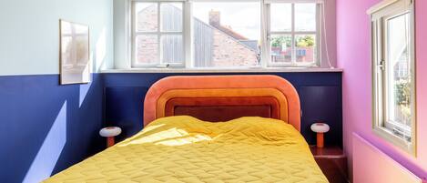 Una habitación con cama, ventana y radiador.