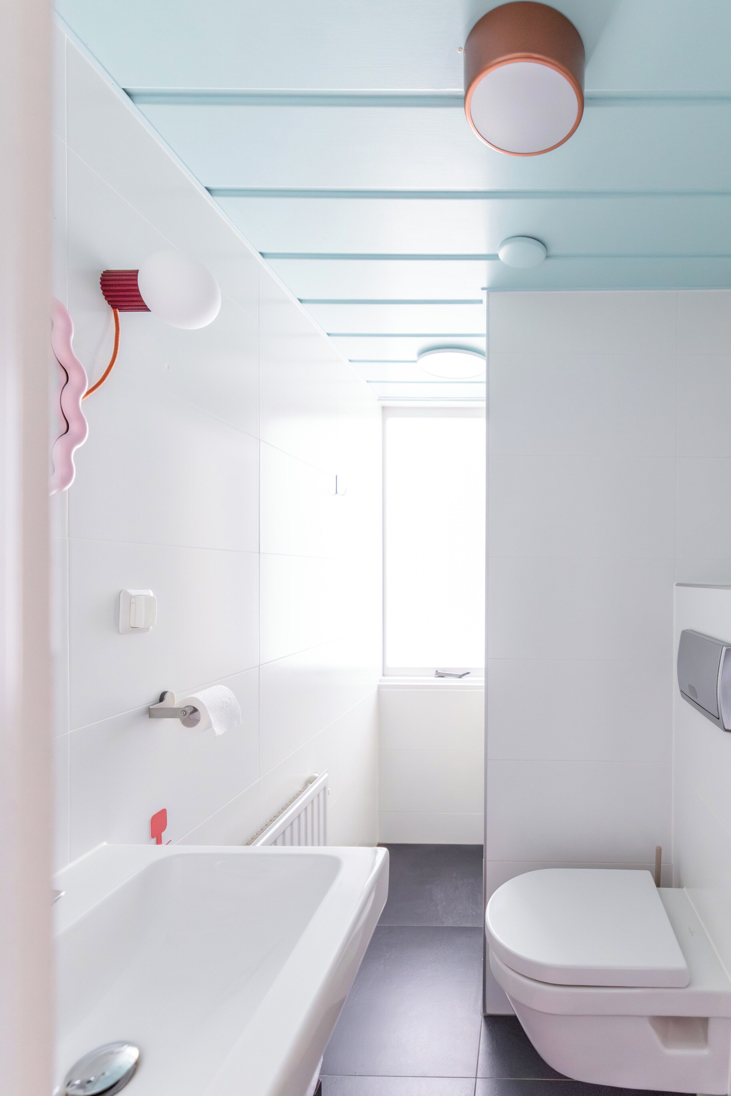Un baño con una bañera blanca, un inodoro y un perchero para toallas.