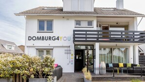A two-story building with a sign reading 'DOMBURG4YOU'. - Domburg4you (Domburg)