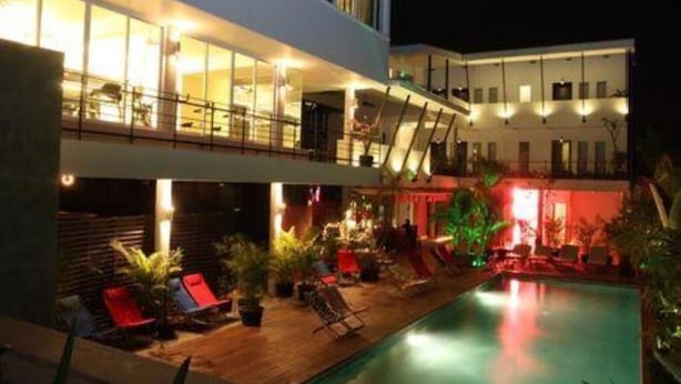 A modern hotel with a rooftop pool area, outdoor seating, and a well-lit interior. - MEN's Resort & Spa - Caters to Gay Men (Siem Reap)