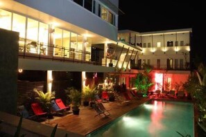 A modern hotel with a rooftop pool area, outdoor seating, and a well-lit interior. - MEN's Resort & Spa - Caters to Gay Men (Siem Reap)