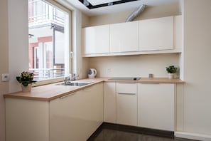 Eine moderne Küche mit Fenster, Spüle und Schränken.