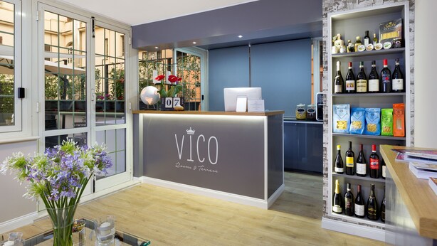 A reception desk with a sign reading "VICO" and a wine display to the right. - Vico Rooms and Terrace (Rome)