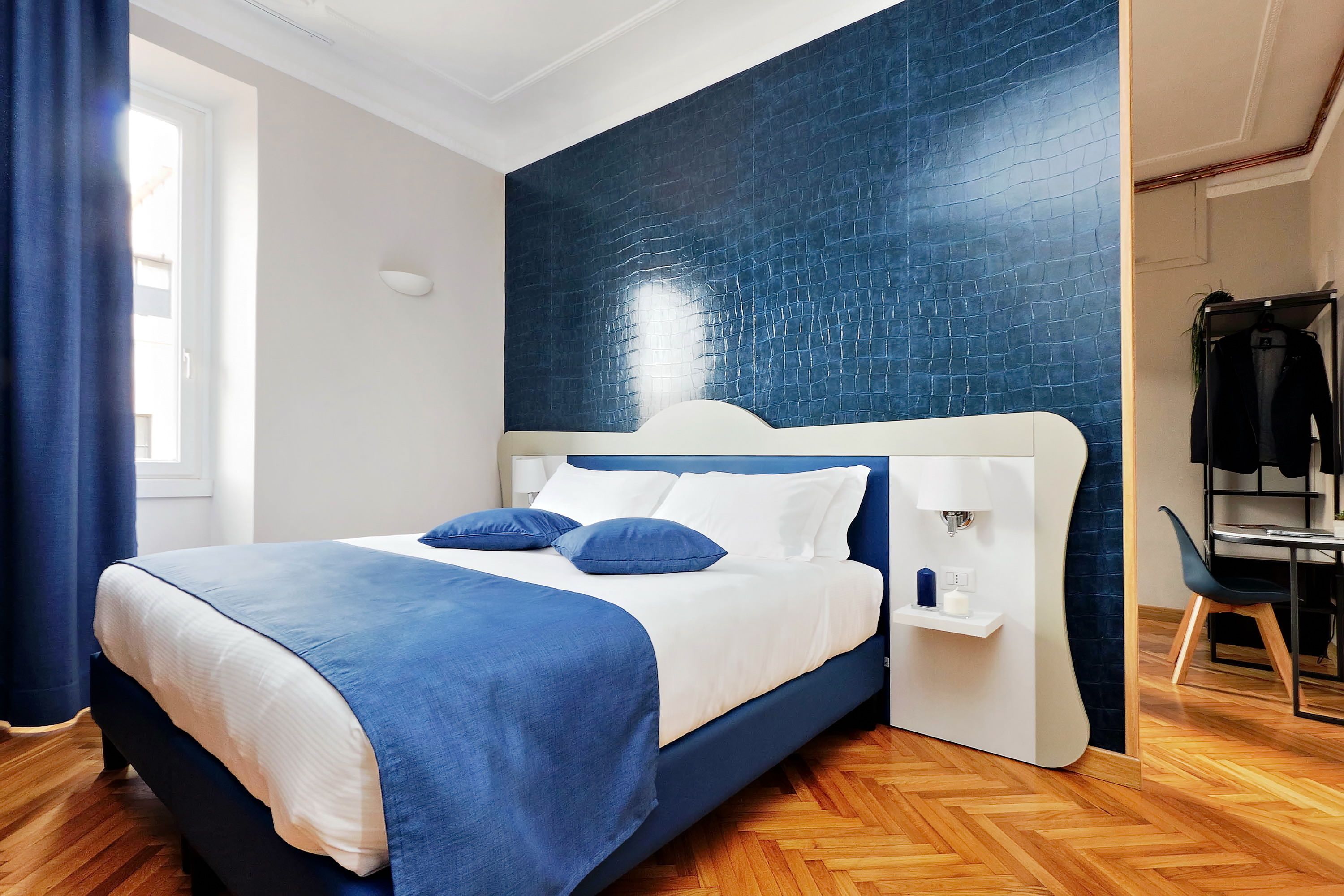 A modern bedroom with a bed, a nightstand, and a built-in desk.