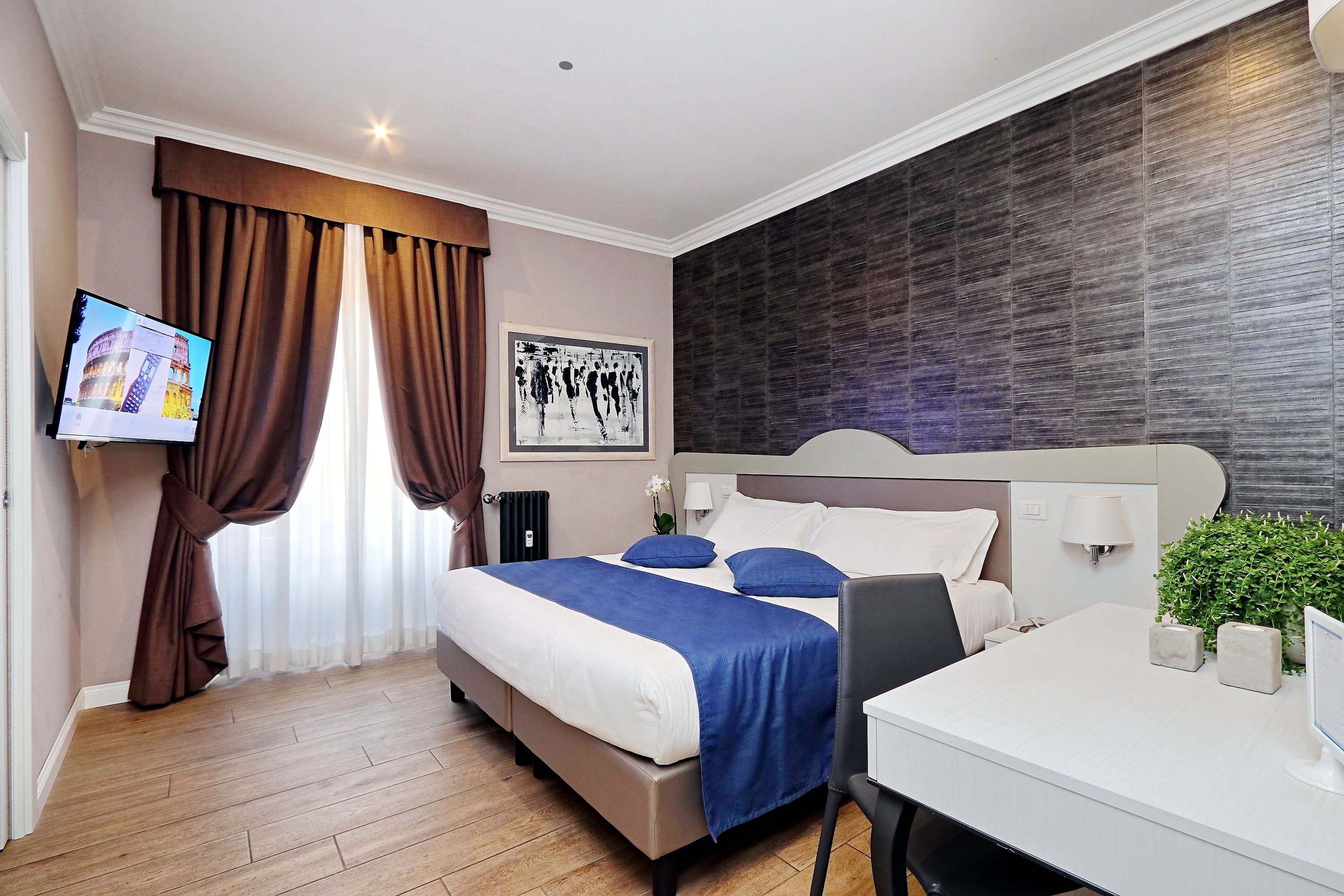 Habitación de hotel moderna con una cama grande, un escritorio, un televisor y vistas a la Torre Eiffel.