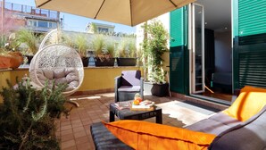 A patio with outdoor furniture, a hanging chair, and potted plants. - Vico Rooms and Terrace (Rome)