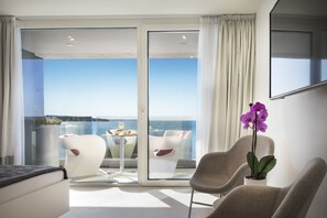 A modern room with a balcony, a flat-screen TV, and a potted orchid. - Rivalmare Boutique Hotel (Novigrad)