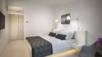 A modern bedroom with a bed, bedside table, lamp, and artwork on the wall.