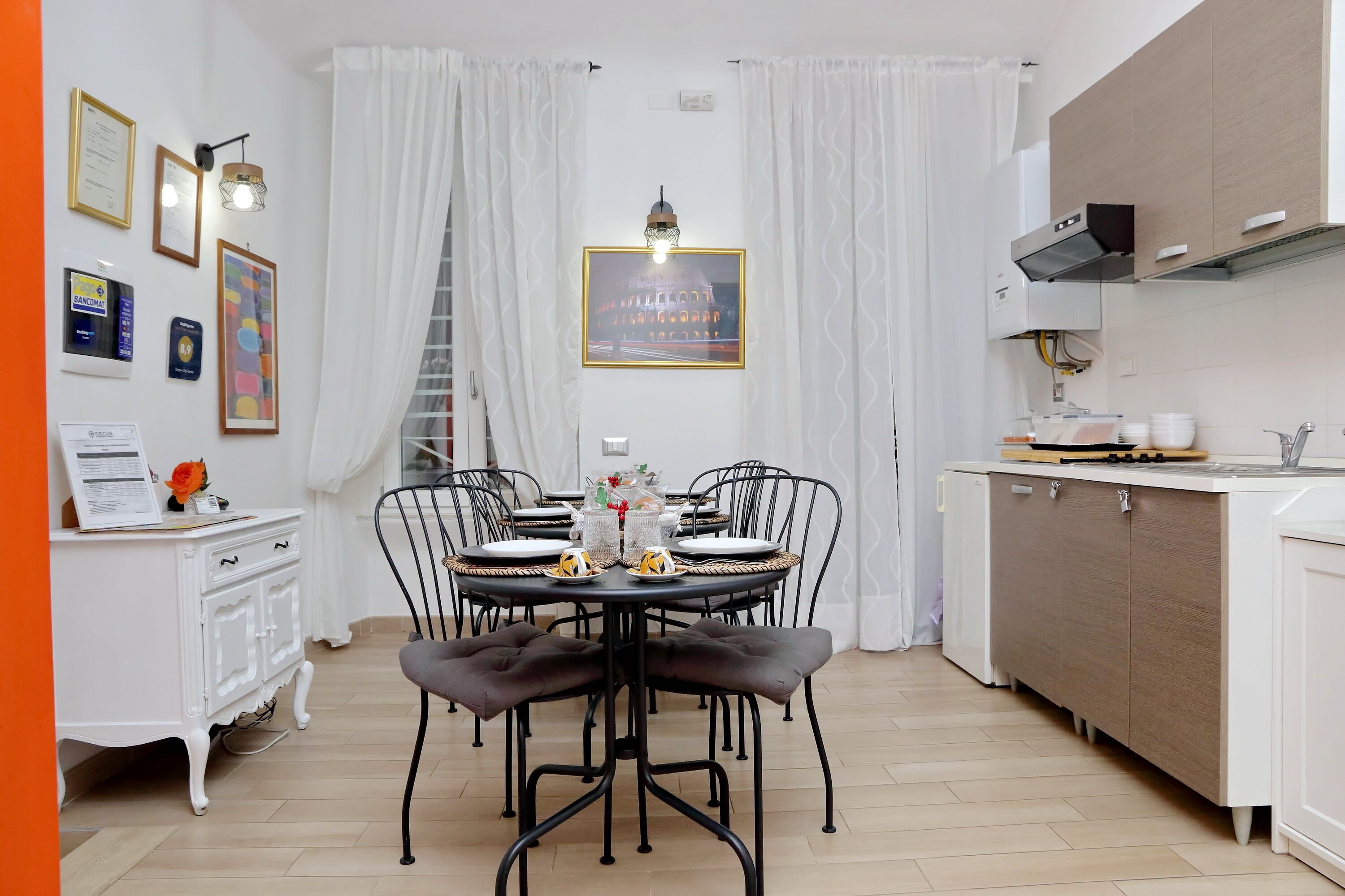 A dining area with a round table, black chairs, and a white cabinet.
