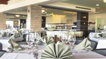 A restaurant with tables set for dining, featuring neatly folded napkins and wine glasses.