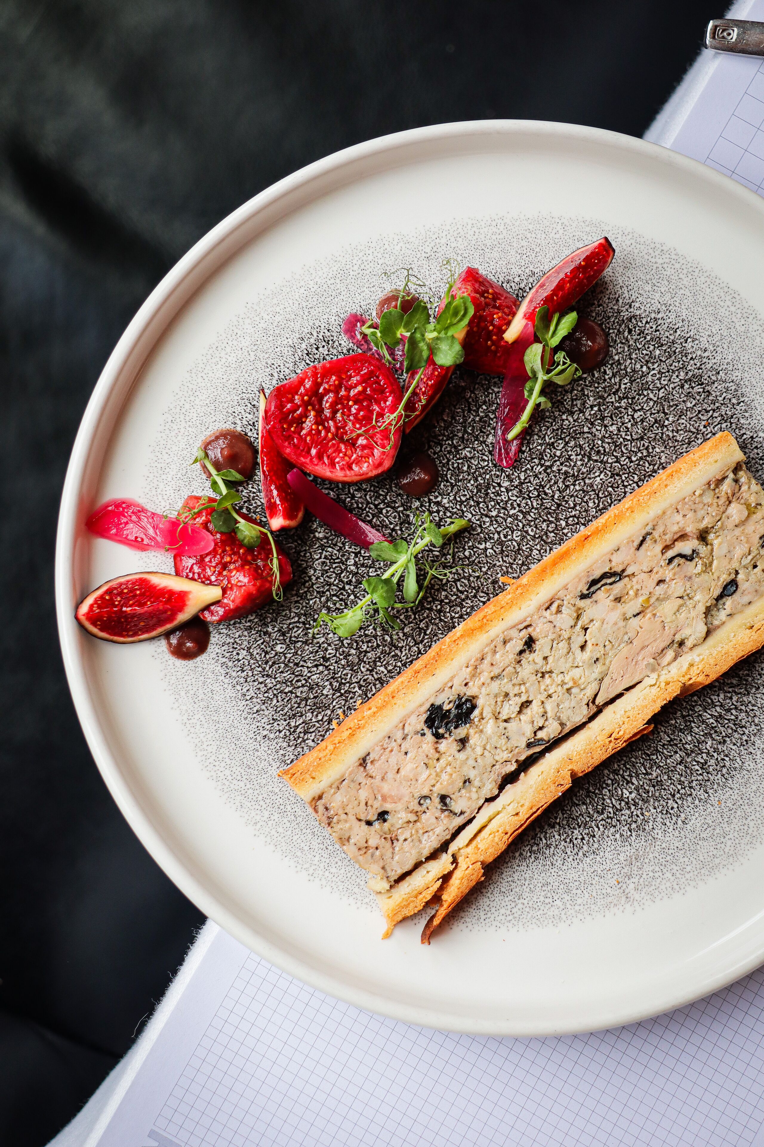 Une assiette avec une tranche de pain et divers fruits et légumes.