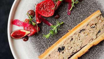 Un plato con una rebanada de pan y diversas frutas y verduras.