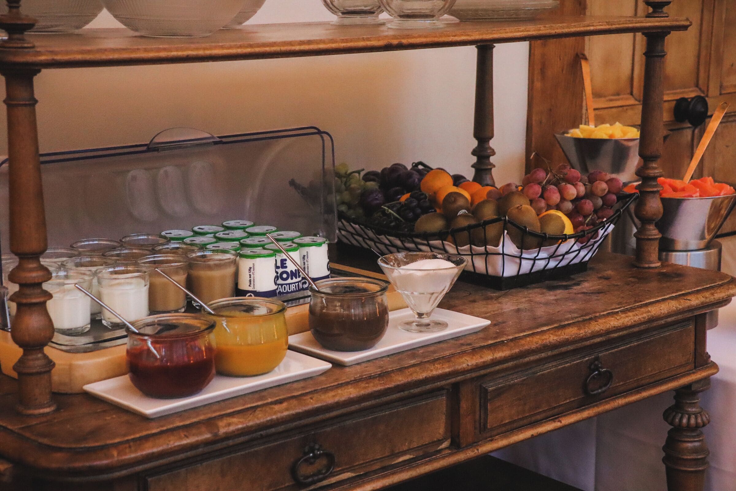 A buffet table with various food items and condiments.