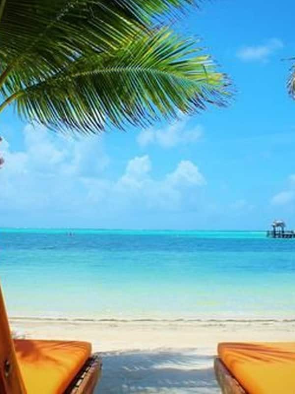 Relax on the sandy shore with a tranquil view of the calm sea.
