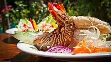 Ein Teller mit gegrilltem Hummer Schwanz, Reis und verschiedenen Gemüsesorten.