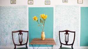 A room with teal walls, a wooden table, and two chairs. - Next Stop Roma Affittacamere Casilino (Rome)