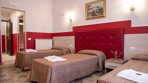 A hotel room with two single beds, a red headboard, a nightstand, a radiator, and a painting on the wall. - Domus Napoleone (Rome)
