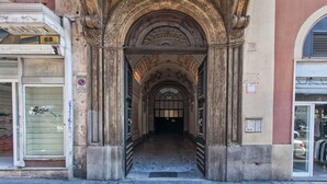 An arched entrance with a tiled floor leading into a building. - Domus Napoleone (Rome)