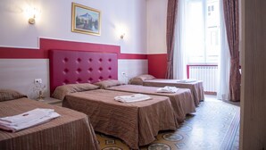 A hotel room with four beds, a large pink headboard, and a painting on the wall. - Domus Napoleone (Rome)