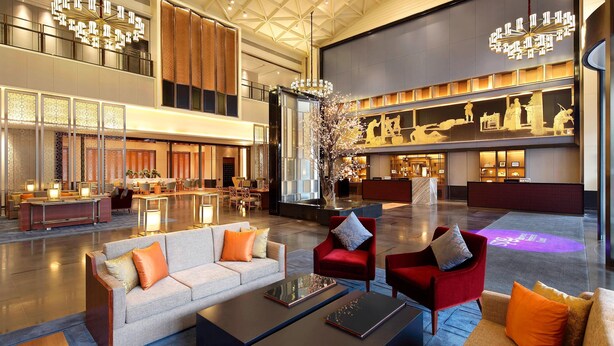 A spacious lobby with a high ceiling, a reception desk, seating areas, and a decorative tree centerpiece. - Four Points by Sheraton Chengdu, Anren (Chengdu)