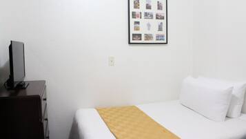Ein Hotelzimmer mit einem Bett, einem Schminktisch und einer Wandcollage mit Fotos.