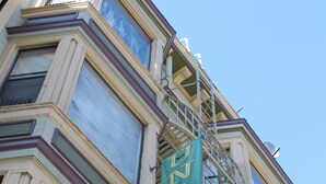 A building with a green banner advertising a hotel. - Union Hotel (San Francisco)