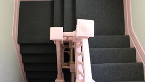 A staircase with dark carpeting and a pink handrail. - Union Hotel (San Francisco)