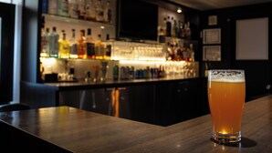 Un coin bar avec un verre de bière posé sur un comptoir en bois.