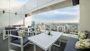 A modern rooftop lounge with white furniture, a city view, and a clear sky. - Royal Tulip Achrafieh (Beirut)