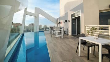 Una piscina al aire libre de temporada, sillones reclinables de piscina
