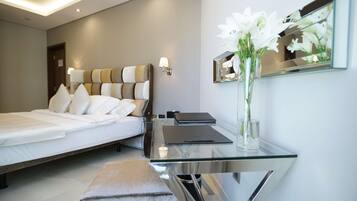 Un dormitorio moderno con cama, mesita de noche y espejo.