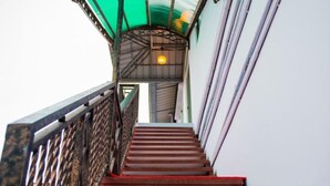A staircase with a metal railing leading to a green-lit area. - Aung Tha Pyay Hotel 2 (Yangon)