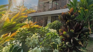 A modern two-story building with a balcony, surrounded by lush tropical plants. - Hotel Secreto La Fortuna (La Fortuna)