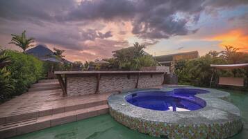 Una piscina en la azotea con mosaicos, rodeada por un muro de ladrillo y escalones que dan acceso a ella.