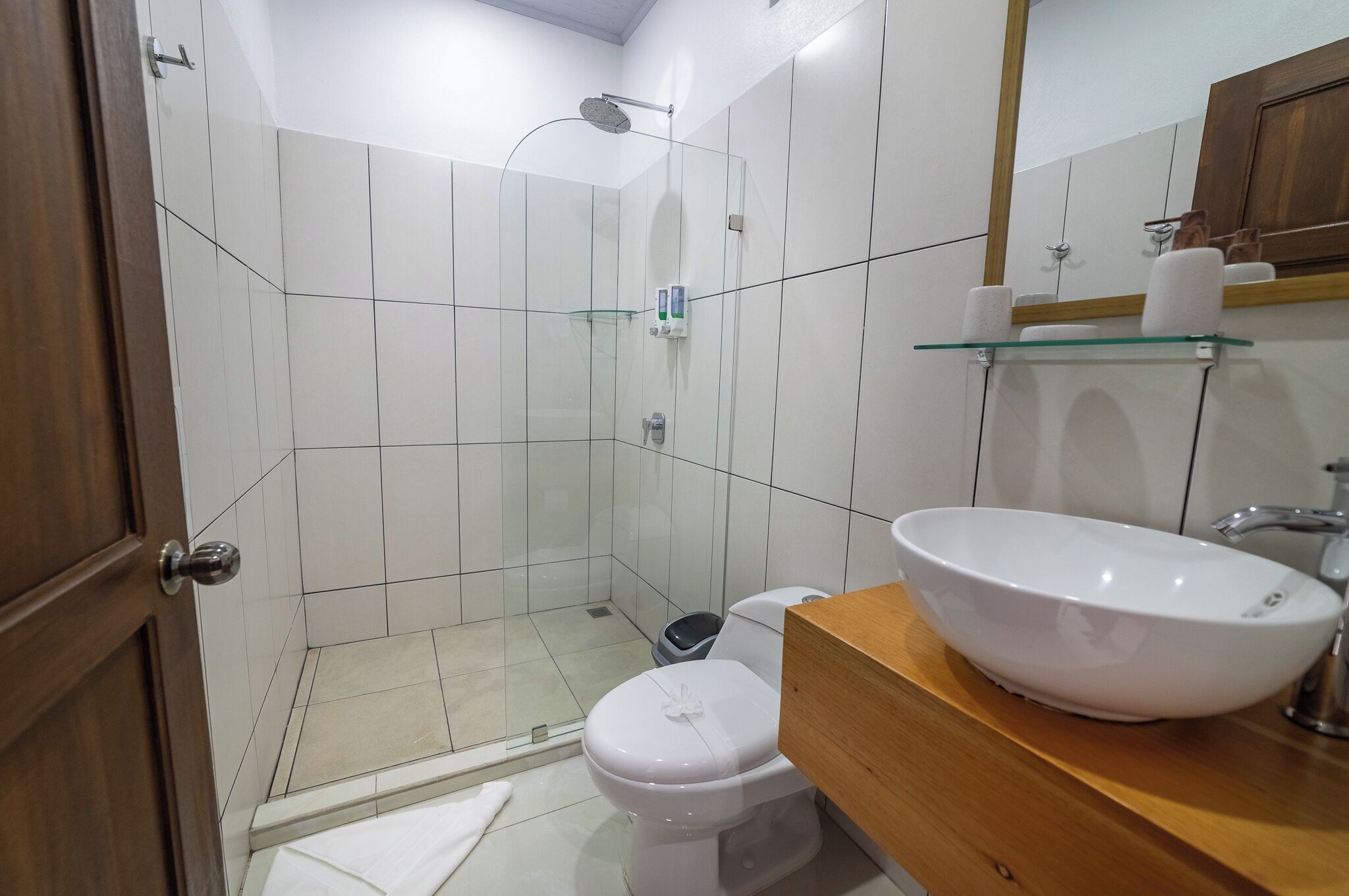 A bathroom with a toilet, sink, and shower.