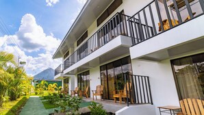 A modern hotel with a two-story structure, outdoor seating area with wooden chairs, and a green pathway leading to the entrance. - Hotel Secreto La Fortuna (La Fortuna)