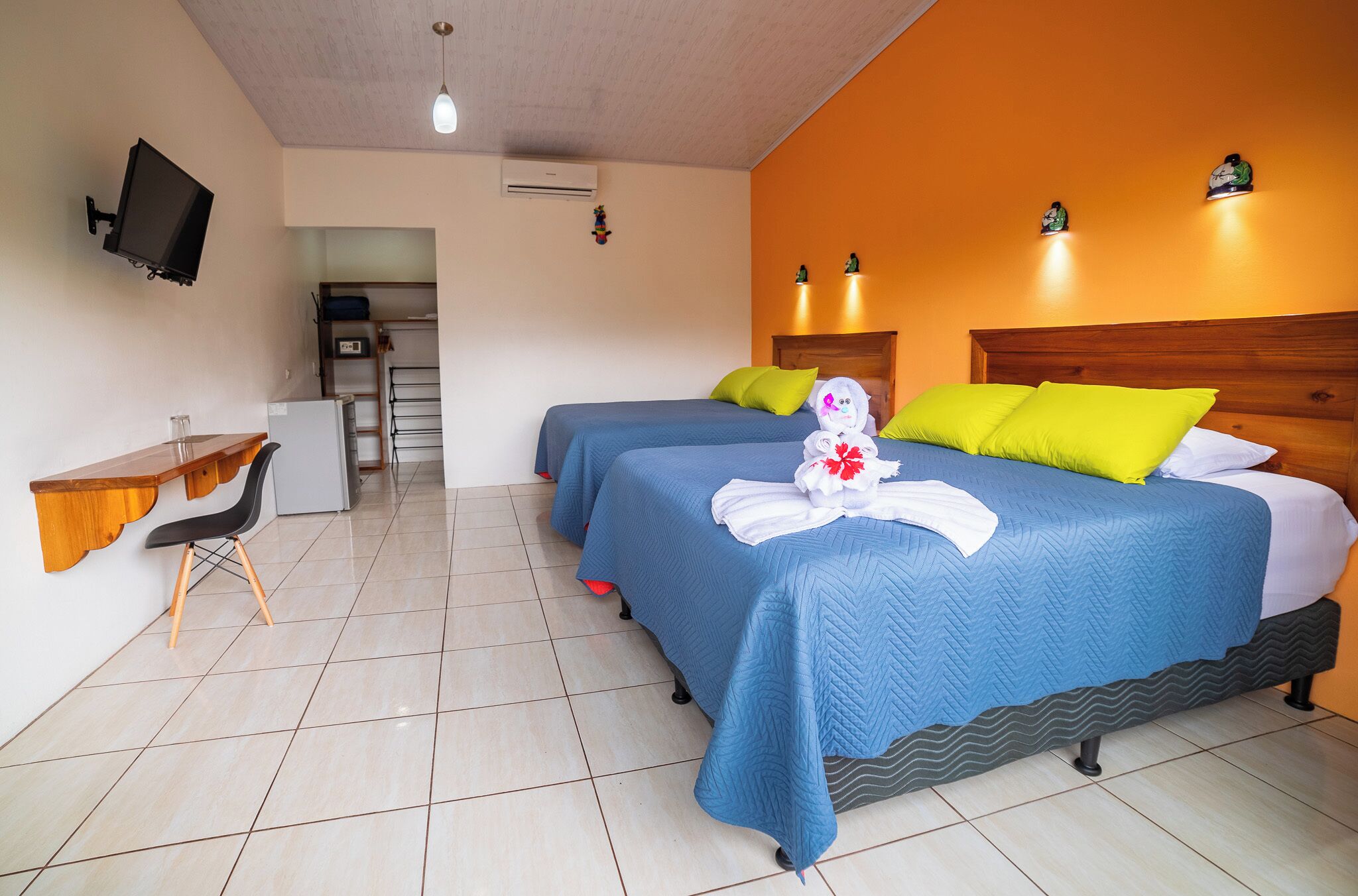 Une chambre d’hôtel avec deux lits, un bureau et une télévision.
