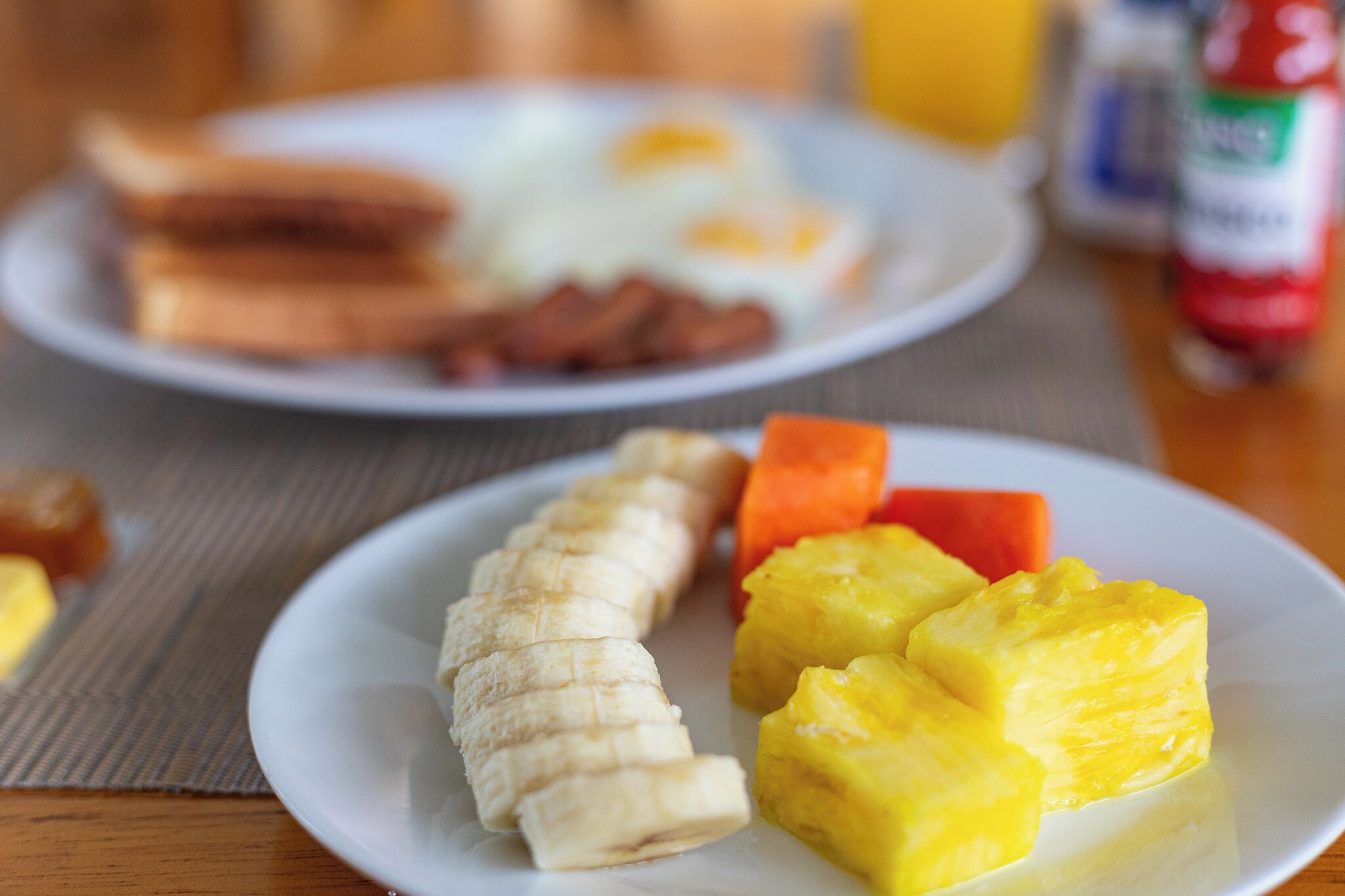 A breakfast plate with sliced bananas and pineapple chunks.