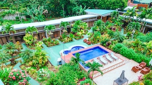 An aerial view of a hotel with a swimming pool surrounded by lush greenery and various plants. - Hotel Secreto La Fortuna (La Fortuna)