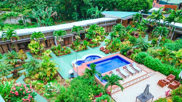 An aerial view of a hotel with a swimming pool surrounded by lush greenery and various plants. - Hotel Secreto La Fortuna (La Fortuna)