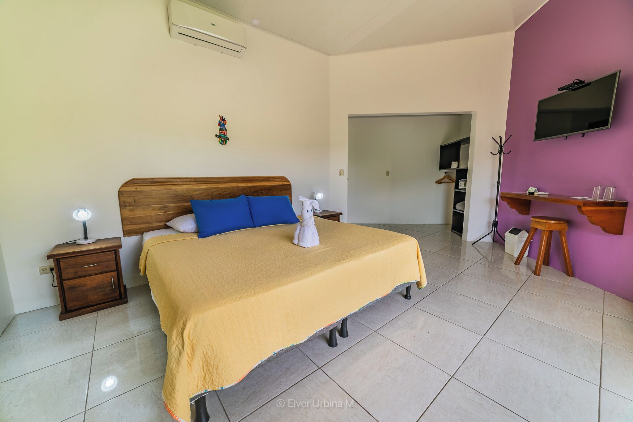 Une chambre à coucher avec un lit, des tables de chevet, une télévision et un bureau.